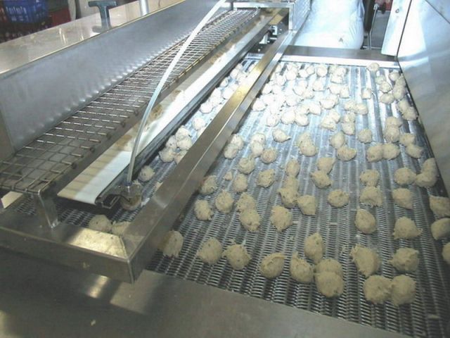 Retractable belt conveyor - products as dough are dropped off at the upstream end of a cryogenic tunnel